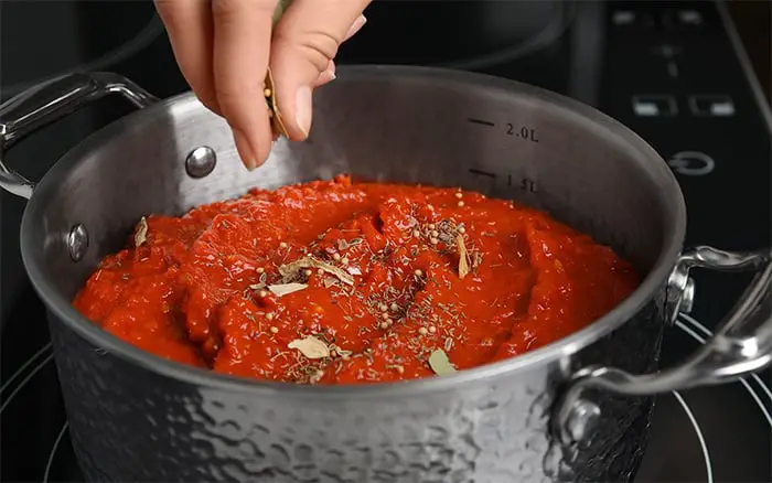 adding herbs to sauce