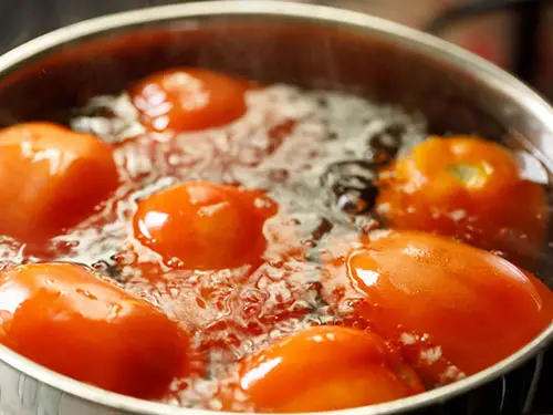 Place the tomatoes in the hot water